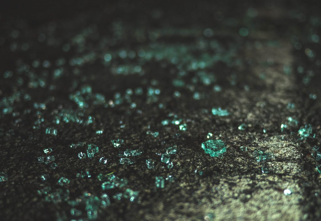 Stock photo of broken glass on asphalt.